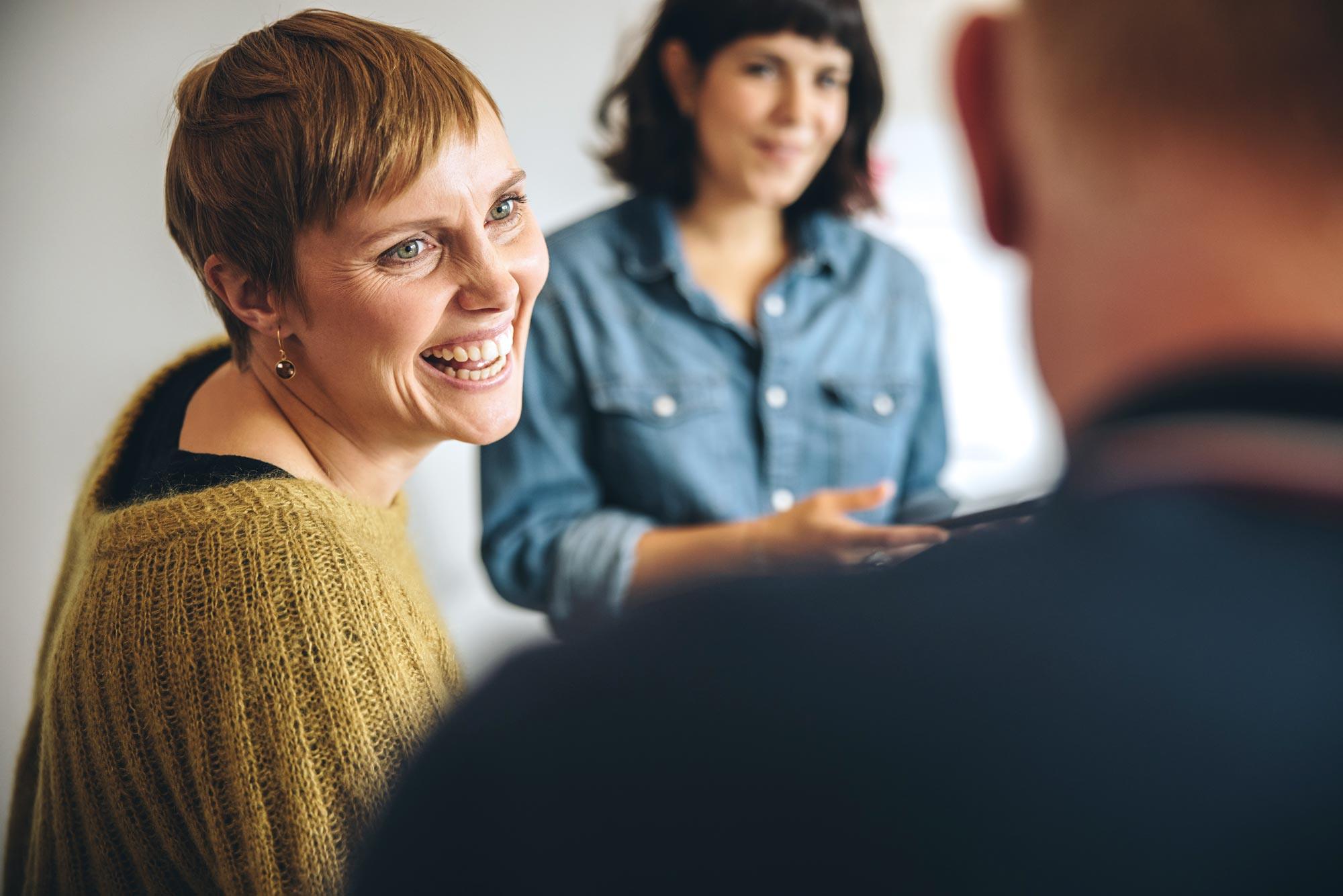 Businesswoman smiling during a meeting in office. Cheerful female professional looking at male colleague and smiling.
